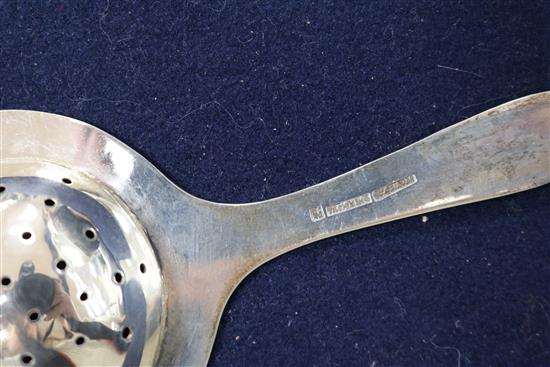 A Chinese silver sugar bowl and two tea strainers.